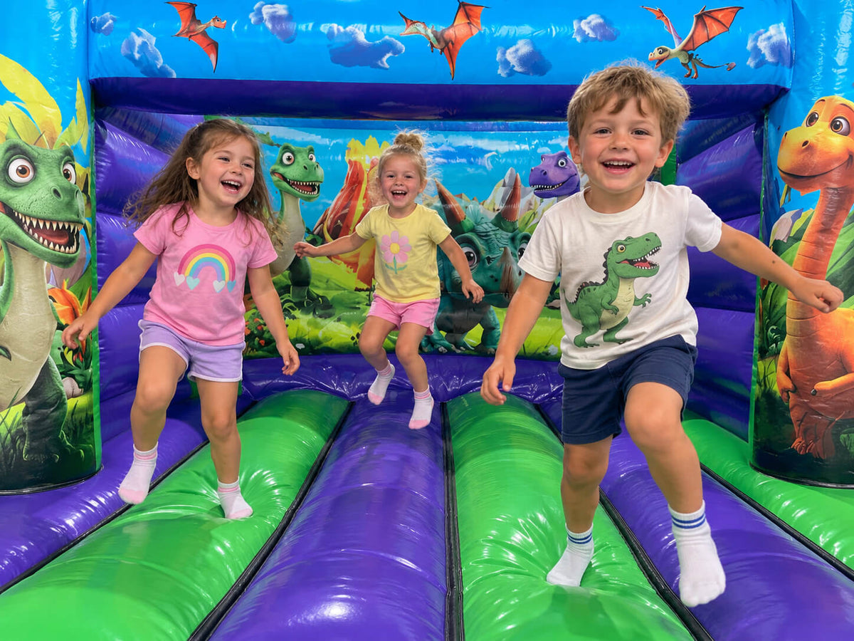 Children having fun on dinosaur themed Airquee indoor inflatable 