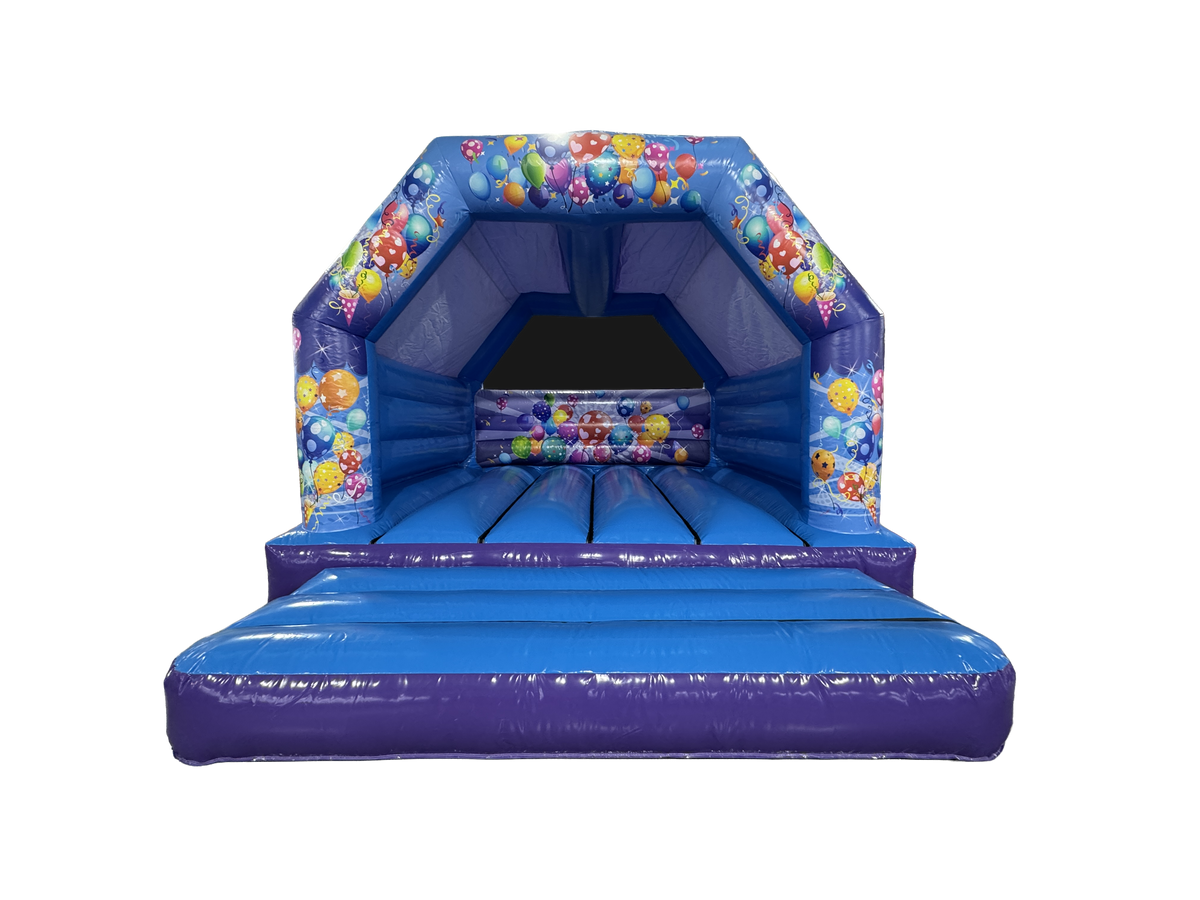 A blue inflatable bounce house with a ball pit and colorful balloon graphics, isolated on a white background.
