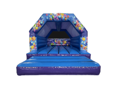A blue inflatable bounce house with a ball pit and colorful balloon graphics, isolated on a white background.
