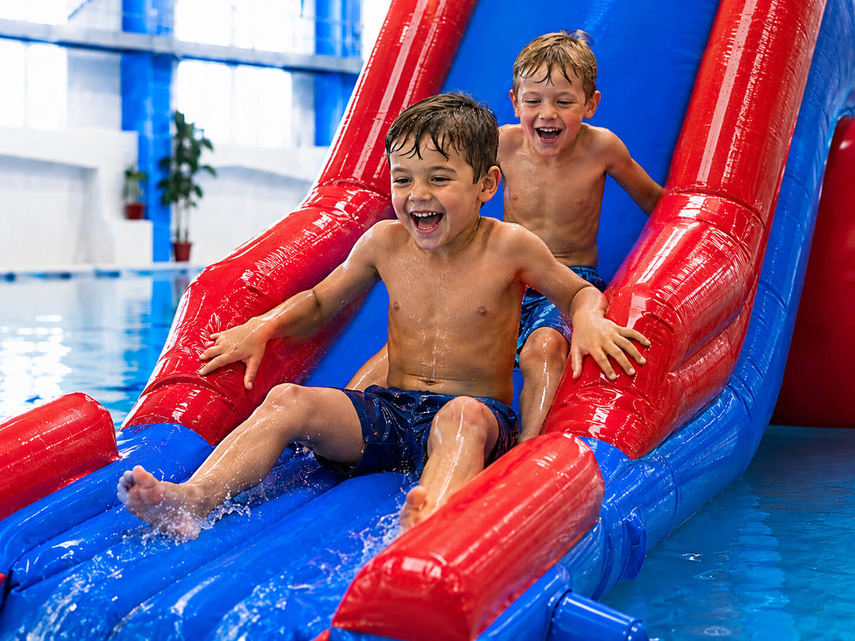 Two young boys on an inflatable water slide
