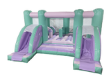 Airquee pastel midi bouncer with two front slides, mint green and lilac inflatable play area with internal obstacles.