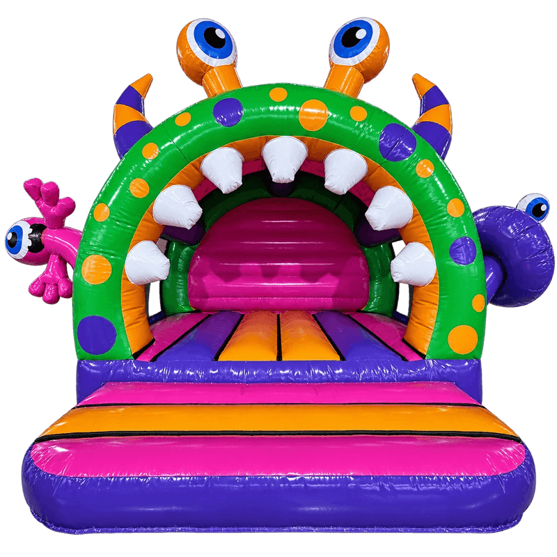 A colorful inflatable monster-themed bounce house with a green arch, purple mouth interior, white teeth, orange and purple spots, eye details on the horns, a pink side mouth, and a purple striped entryway.